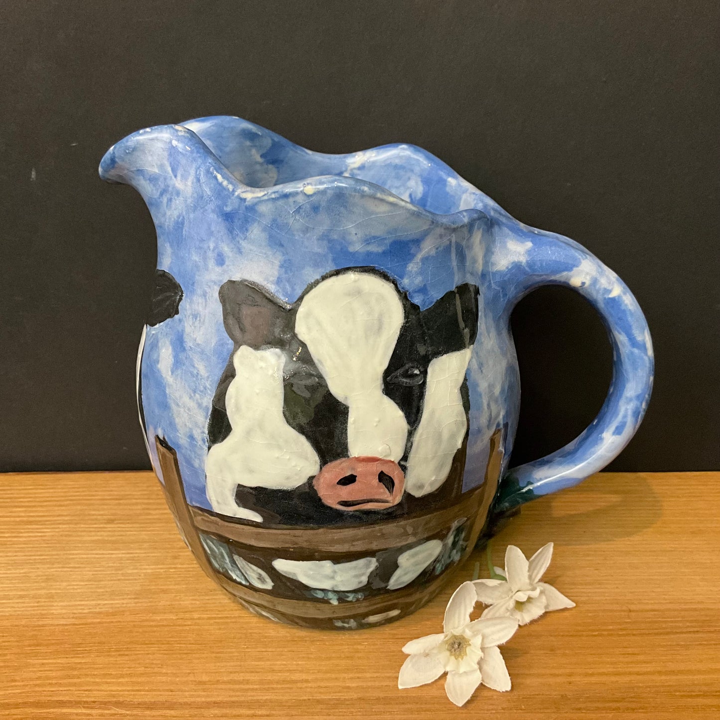 Pitcher with Holsteins on Blue Background