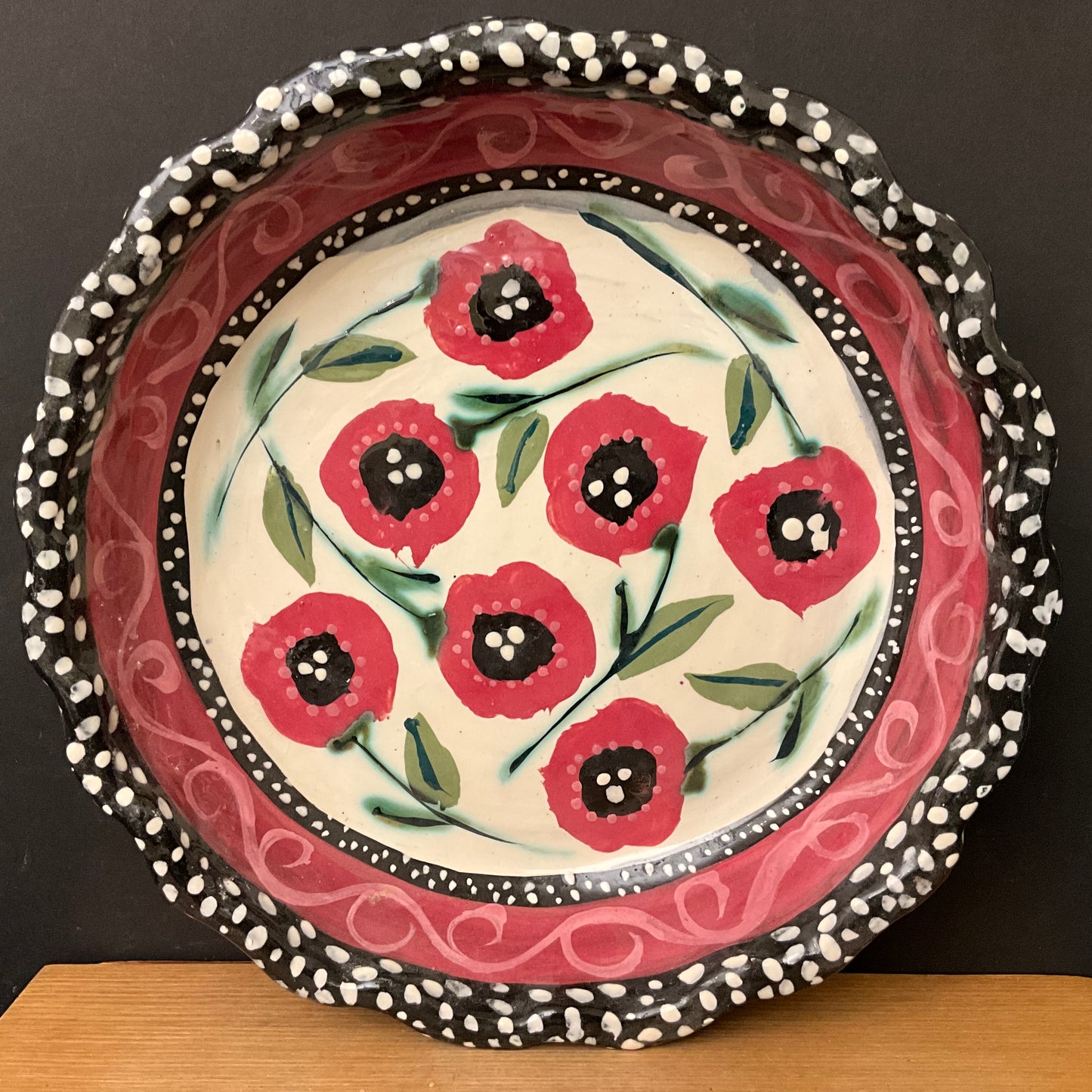 White pie plate with rose red flowers and black dotted trim