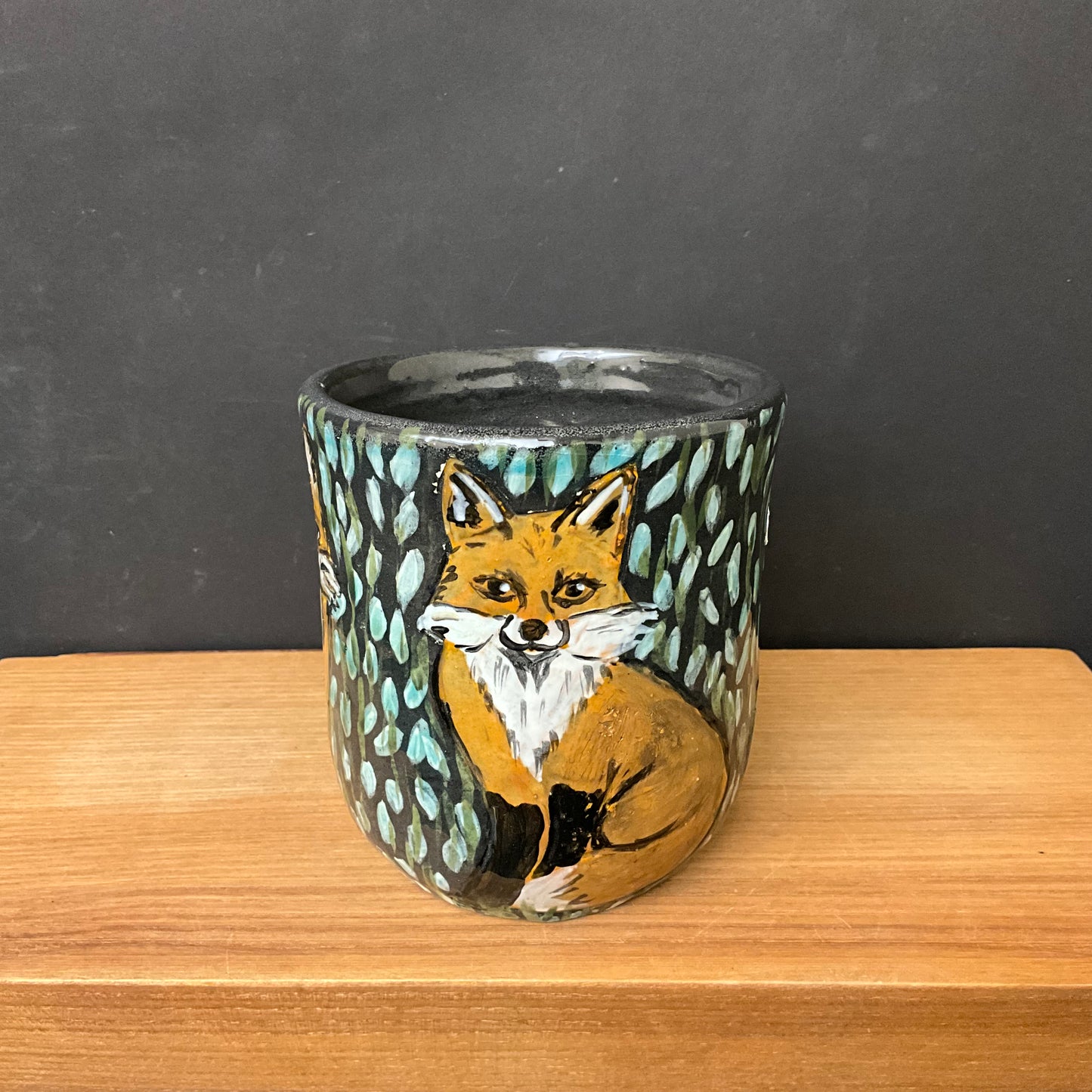 Mug with Carved Foxes and Black Background