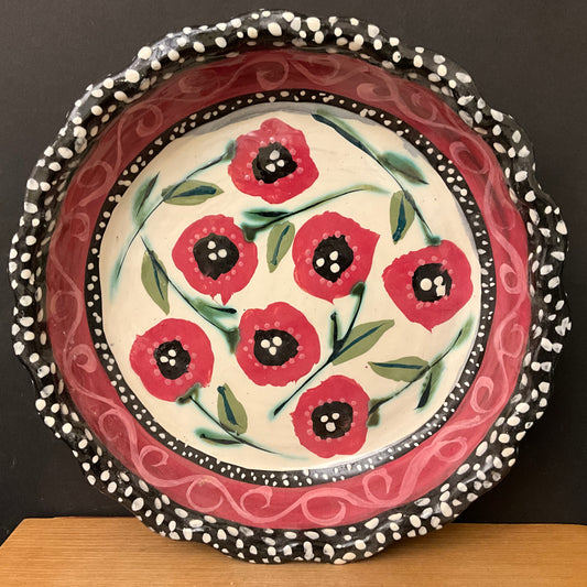 White pie plate with rose red flowers and black dotted trim