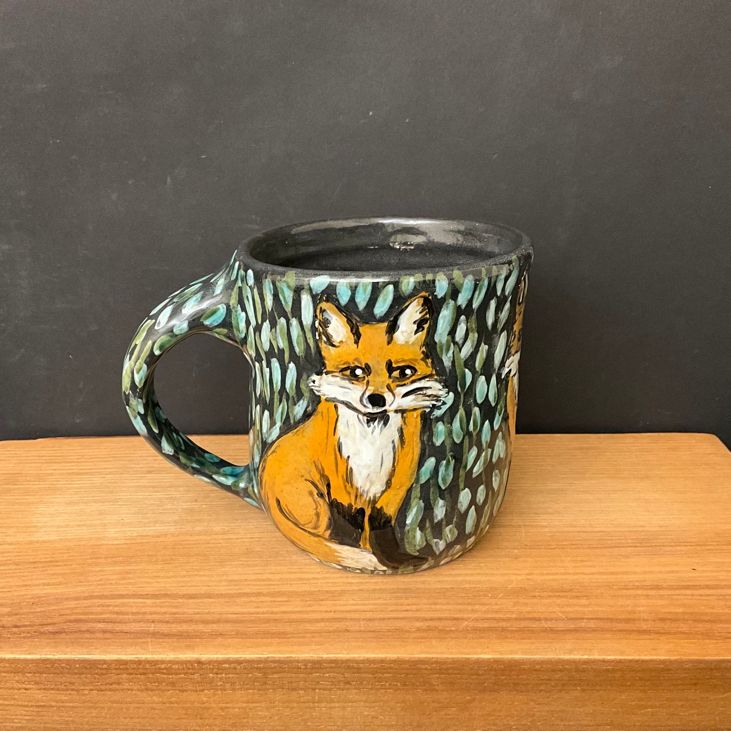 Mug with Carved Foxes and Black Background
